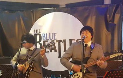 The Blue Beatles Duo performing in grey collarless suits