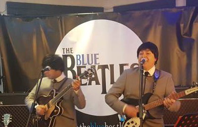 The Blue Beatles Duo performing in grey collarless suits