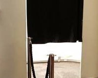white photo booth with black carpet and ropes