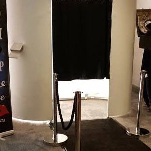 white photo booth with black carpet and ropes