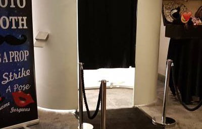 white photo booth with black carpet and ropes