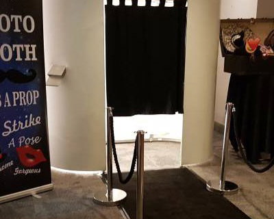 white photo booth with black carpet and ropes