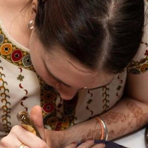 Henna being applied for a wedding guest