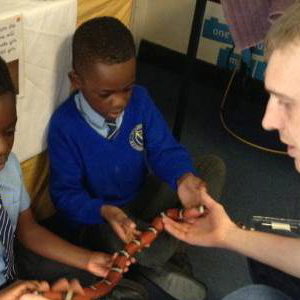 A very brave pupil holding Yazzoo the milk snake