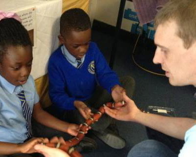 A very brave pupil holding Yazzoo the milk snake