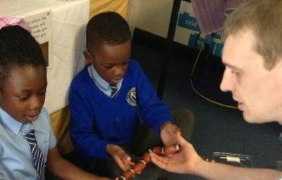 A very brave pupil holding Yazzoo the milk snake