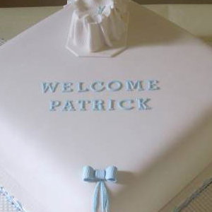 Exquisite boys Christening cake with an baby in a moses basket.