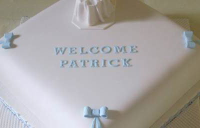 Exquisite boys Christening cake with an baby in a moses basket.
