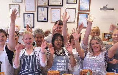 Group of pupils cheering after finishing their chocolate workshop.