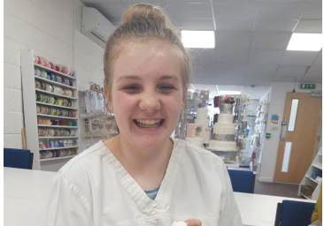 Young girl smiling during making her manikin at one of our Junior workshops.
