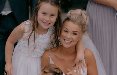 Bride posing with a surprise guest and her daughter