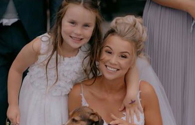 Bride posing with a surprise guest and her daughter