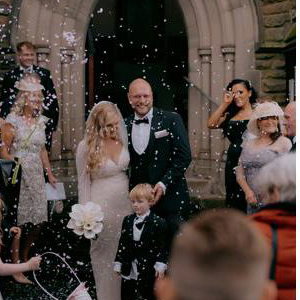 Bride and Groom walking through confetti after church wedding ceremony