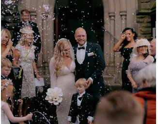 Bride and Groom walking through confetti after church wedding ceremony