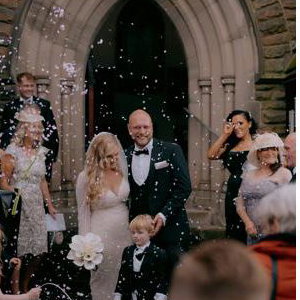 Bride and Groom walking through confetti after church wedding ceremony
