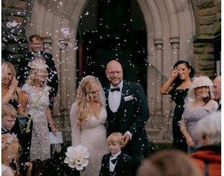 Bride and Groom walking through confetti after church wedding ceremony