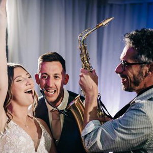 Saxophonist with bride and groom