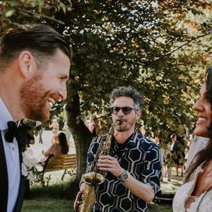 Saxophonist with bride and groom