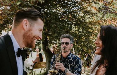 Saxophonist with bride and groom